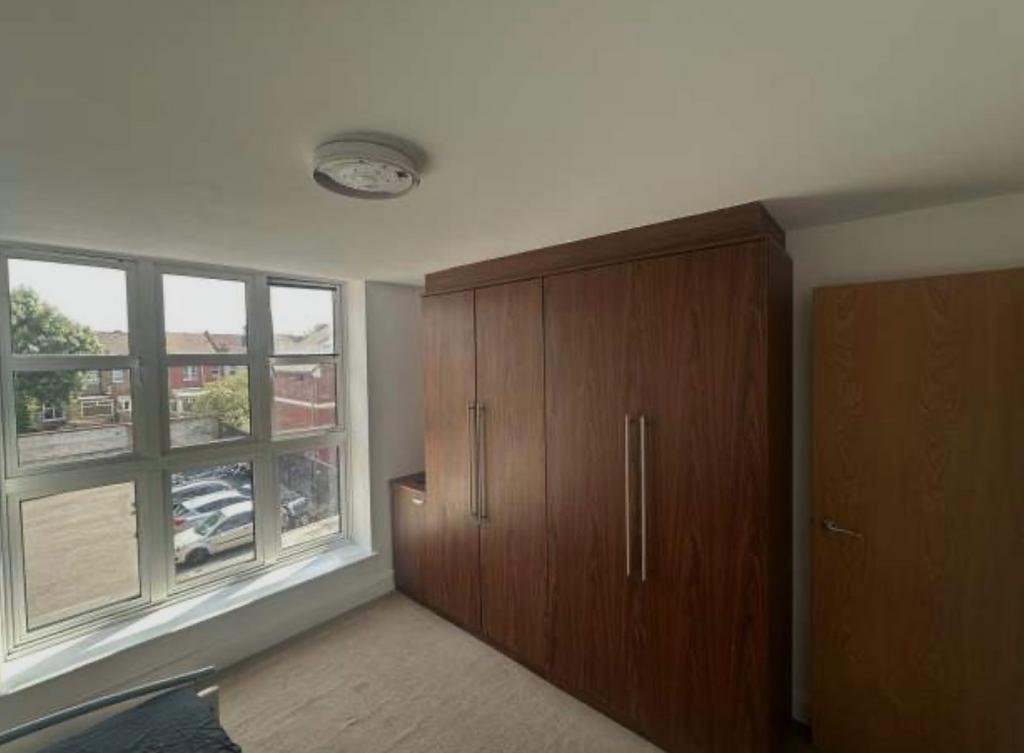 Bright bedroom with a large triple-panel window...