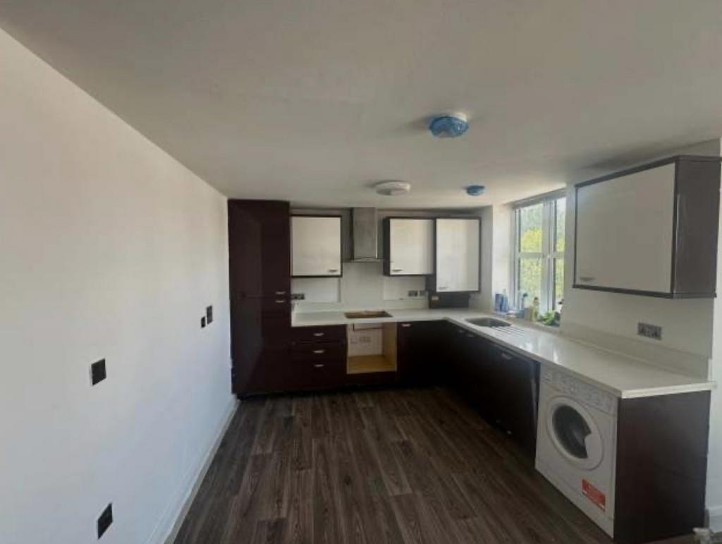 Bright modern kitchen with dark wood cabinetry,...