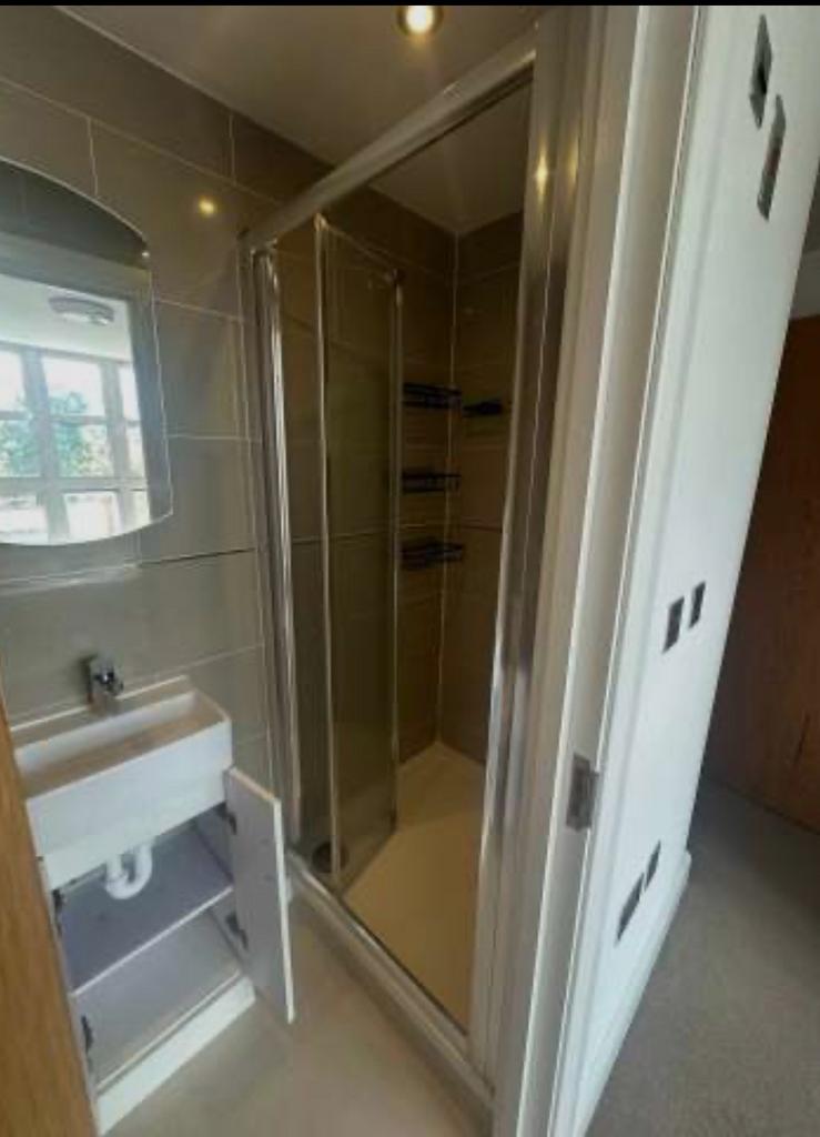 Modern ensuite bathroom with a glass-enclosed s...