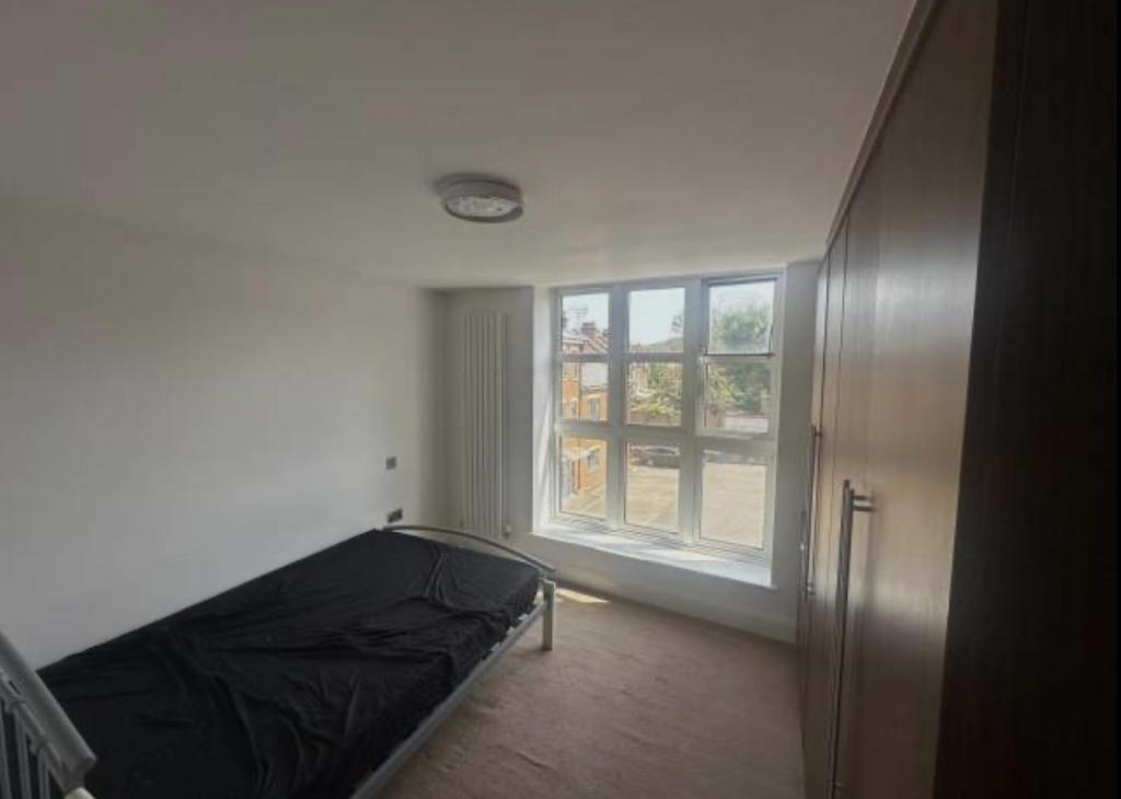 Bright single bedroom with a large window provi...