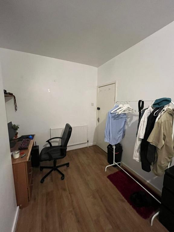 Compact bedroom with a study setup featuring a ...