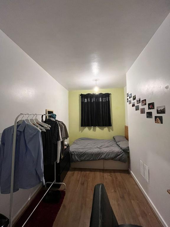 Neat, simply furnished single bedroom with a co...