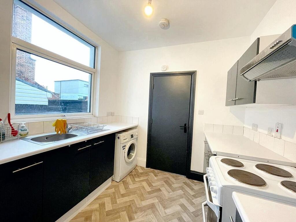 Bright, modern kitchen with large window, fitte...
