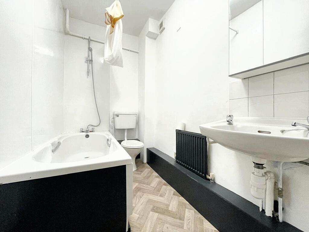 Bright, modern bathroom with a bath and overhea...