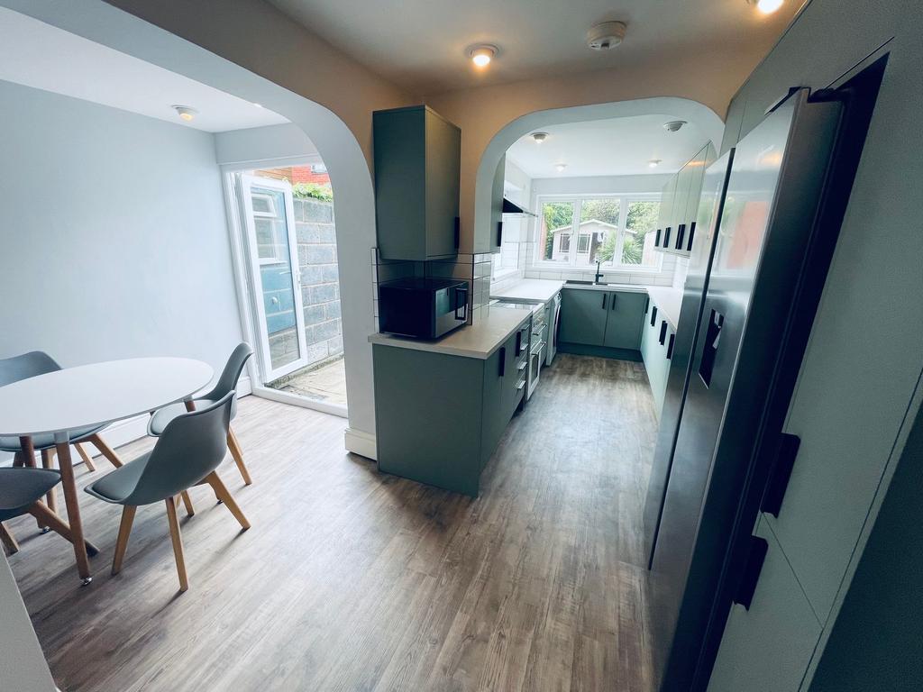 Bright, modern galley kitchen with a stylish di...