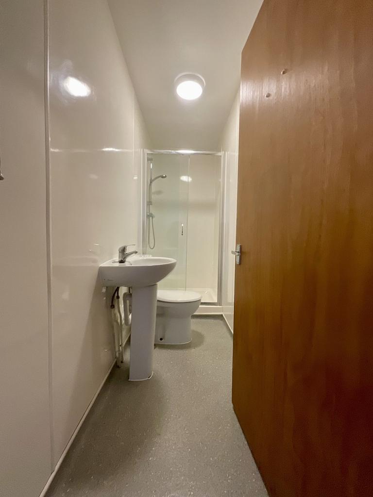 Compact, clean bathroom with a pedestal sink, t...