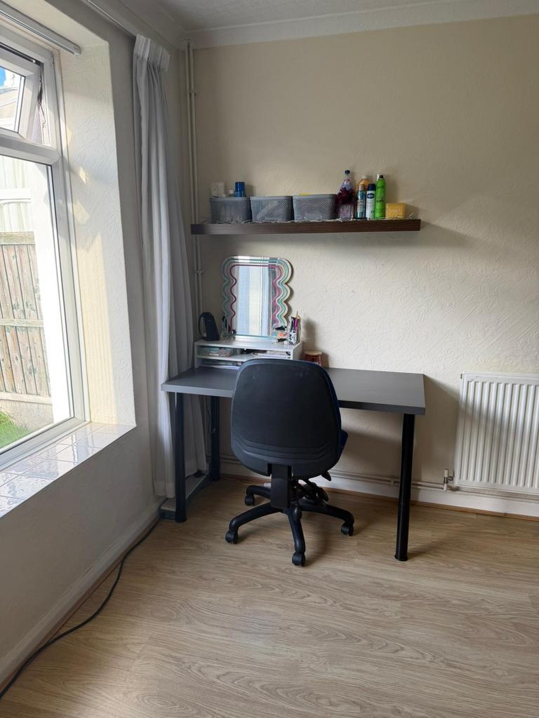 Bright corner workspace with a simple grey desk...
