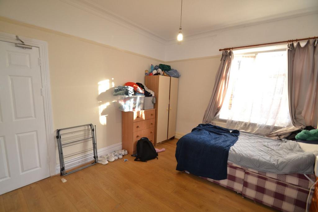 Bright bedroom with large window, wooden floors...