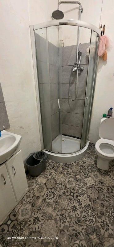 Compact, modern bathroom with a curved glass sh...