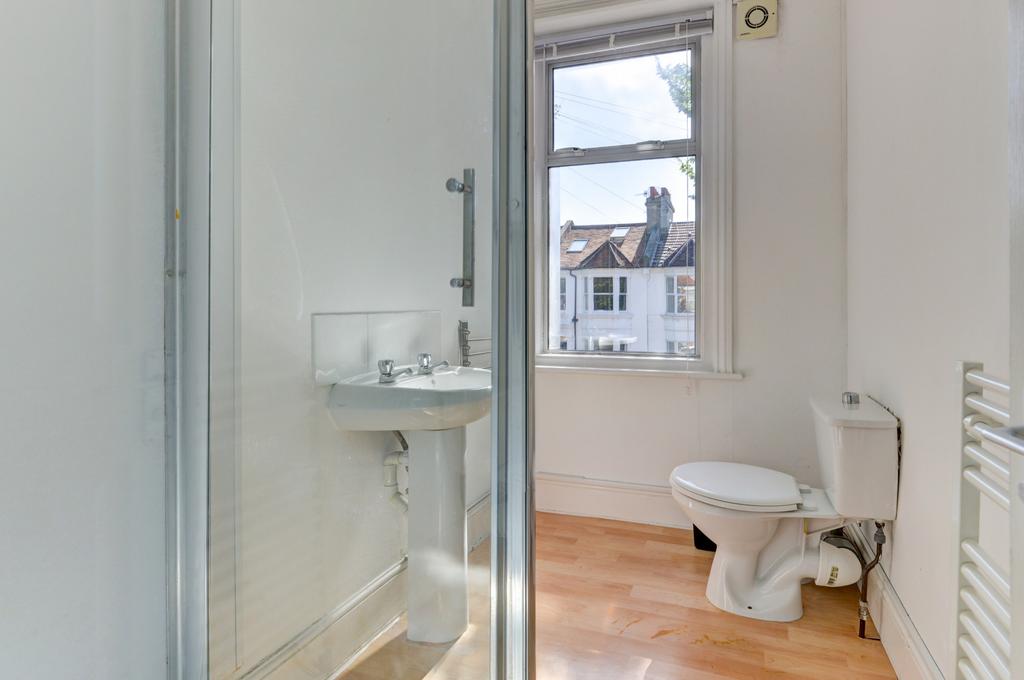 Bright, clean bathroom with a shower enclosure,...