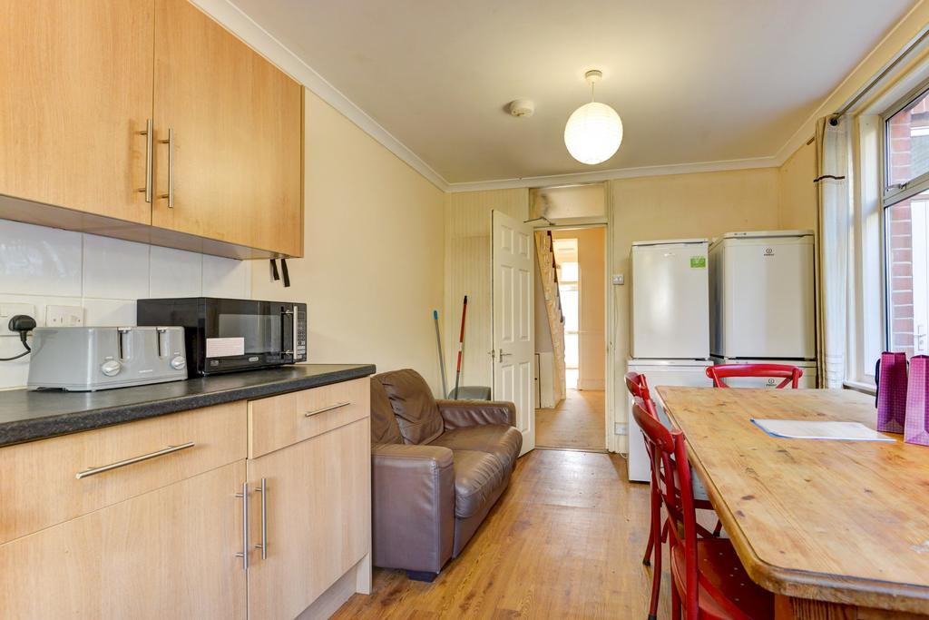 Bright galley-style kitchen with light wood cab...