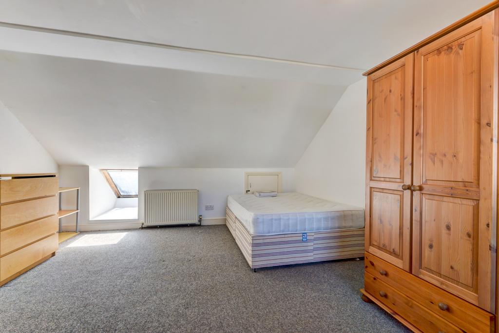 Bright attic single bedroom with a sloped ceili...