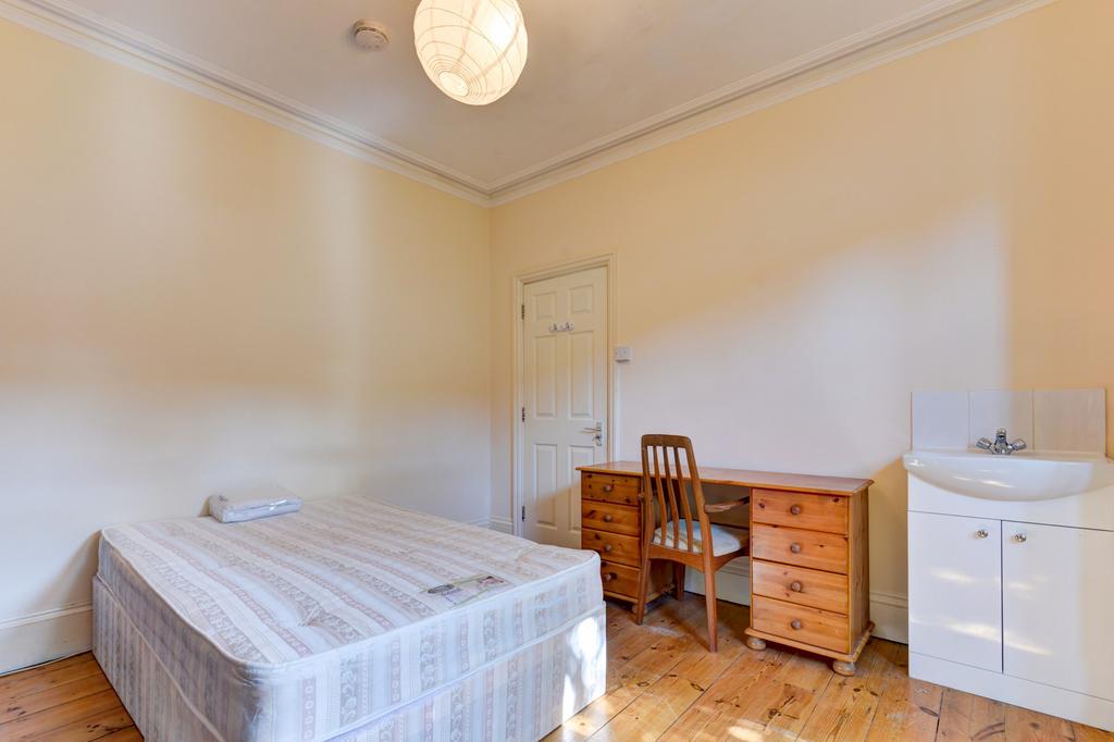 Bright, simply furnished bedroom with a single ...
