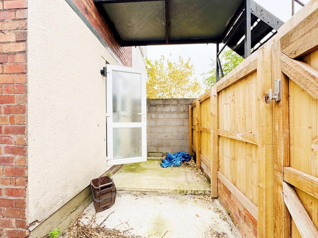 Private paved side yard with a frosted-glass ba...