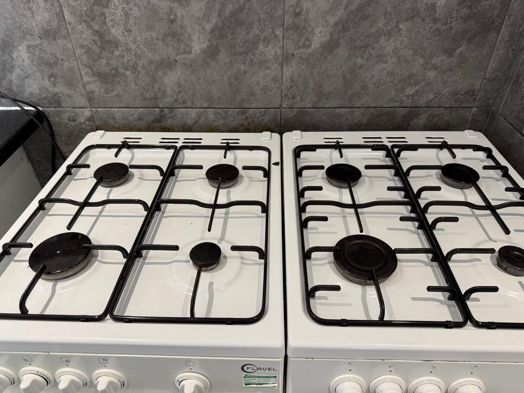 A clean twin gas hob setup with four burners on...