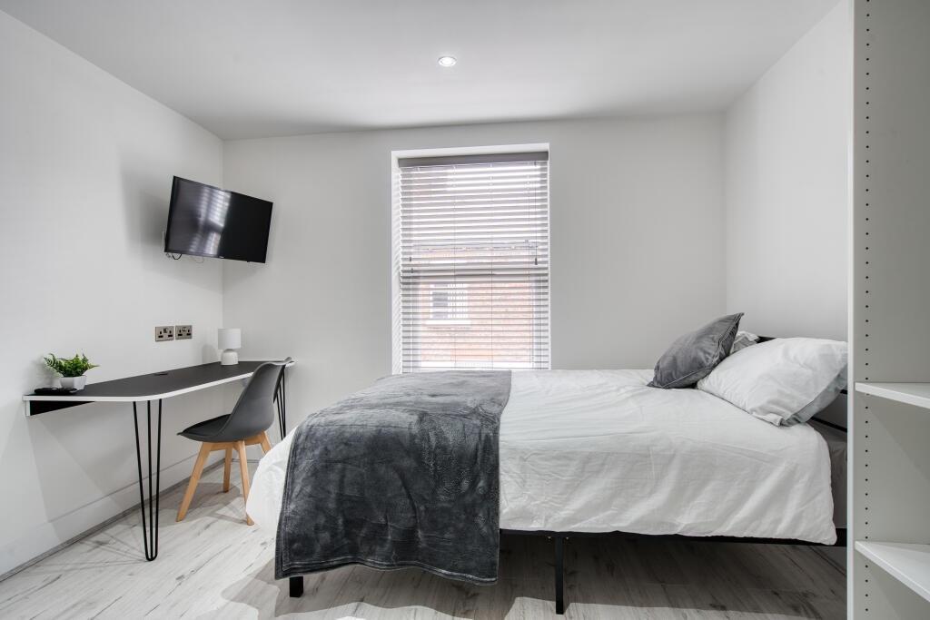 A modern, well-lit single bedroom featuring a c...
