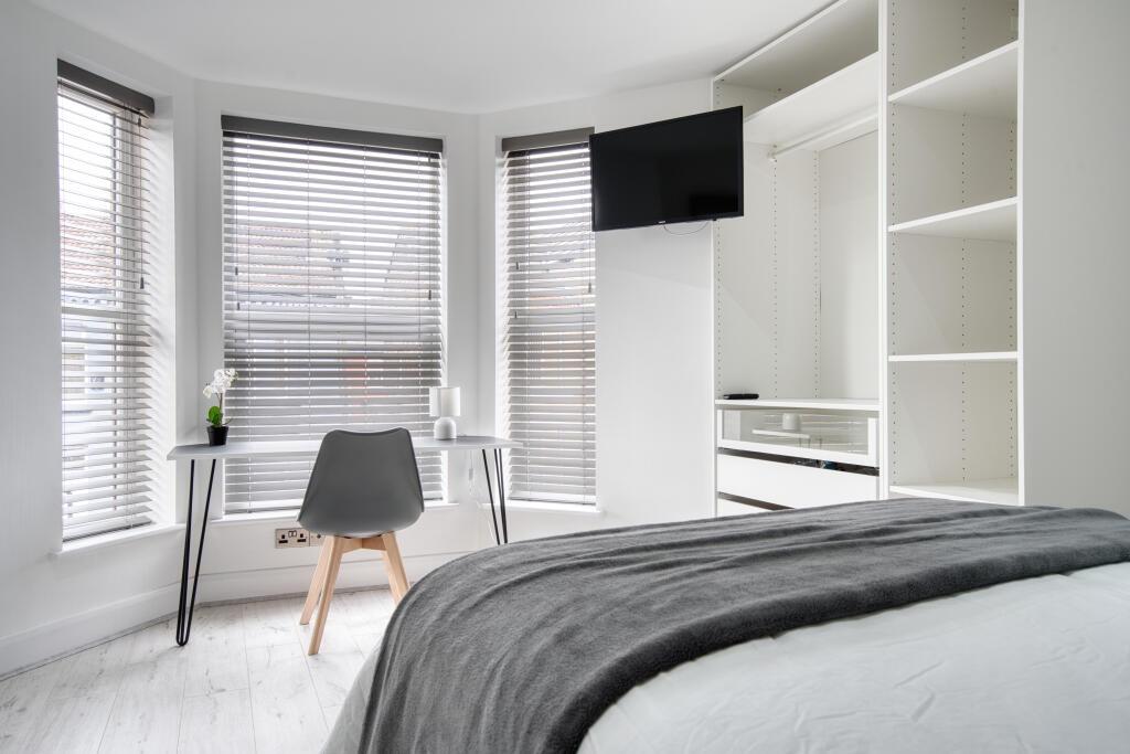 Bright and modern master bedroom featuring a sp...