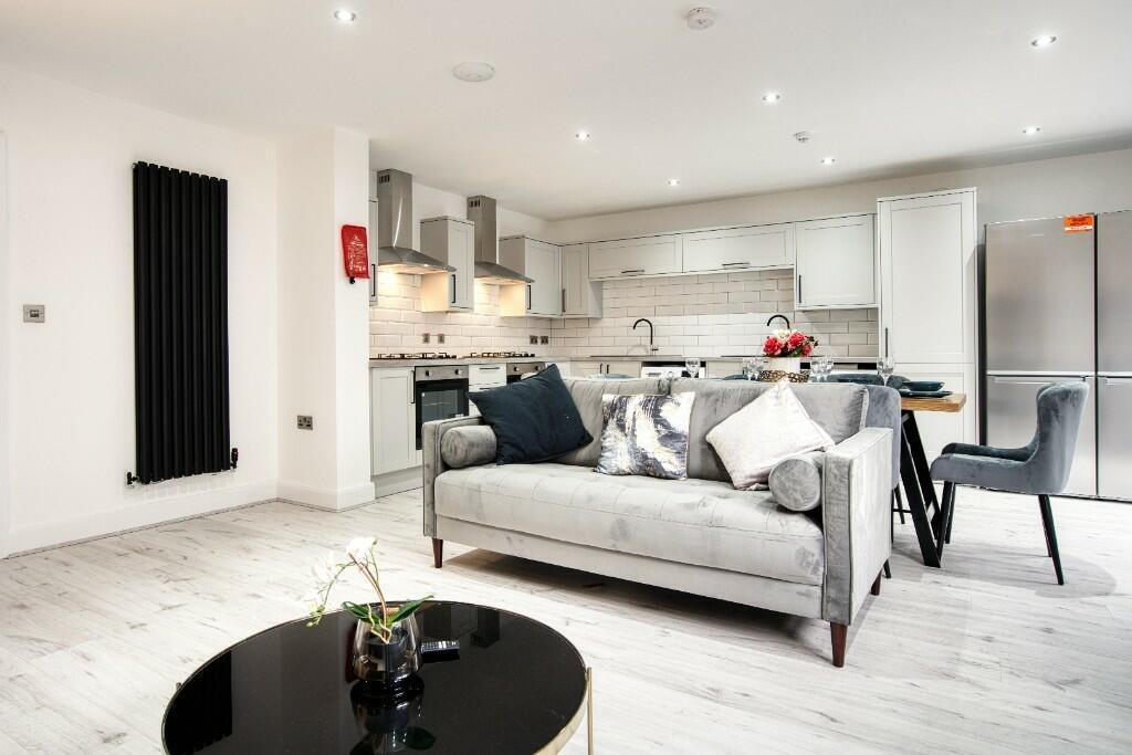 A modern, spacious living room featuring a comf...