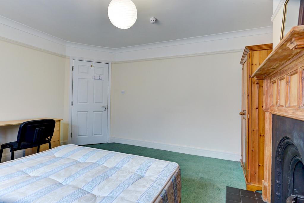Bright double bedroom with a large bed, study d...