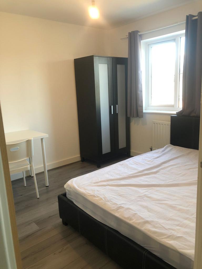 Bright, simply furnished bedroom with a double ...