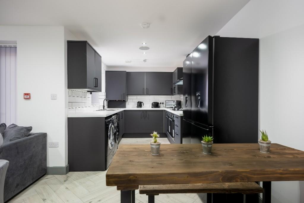 A modern, well-lit kitchen featuring sleek blac...