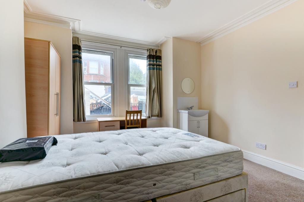 Bright, neutral bedroom with a double bed, ward...