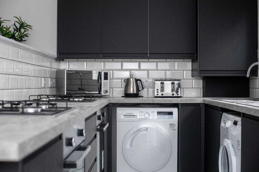 Modern kitchen featuring sleek black cabinets a...