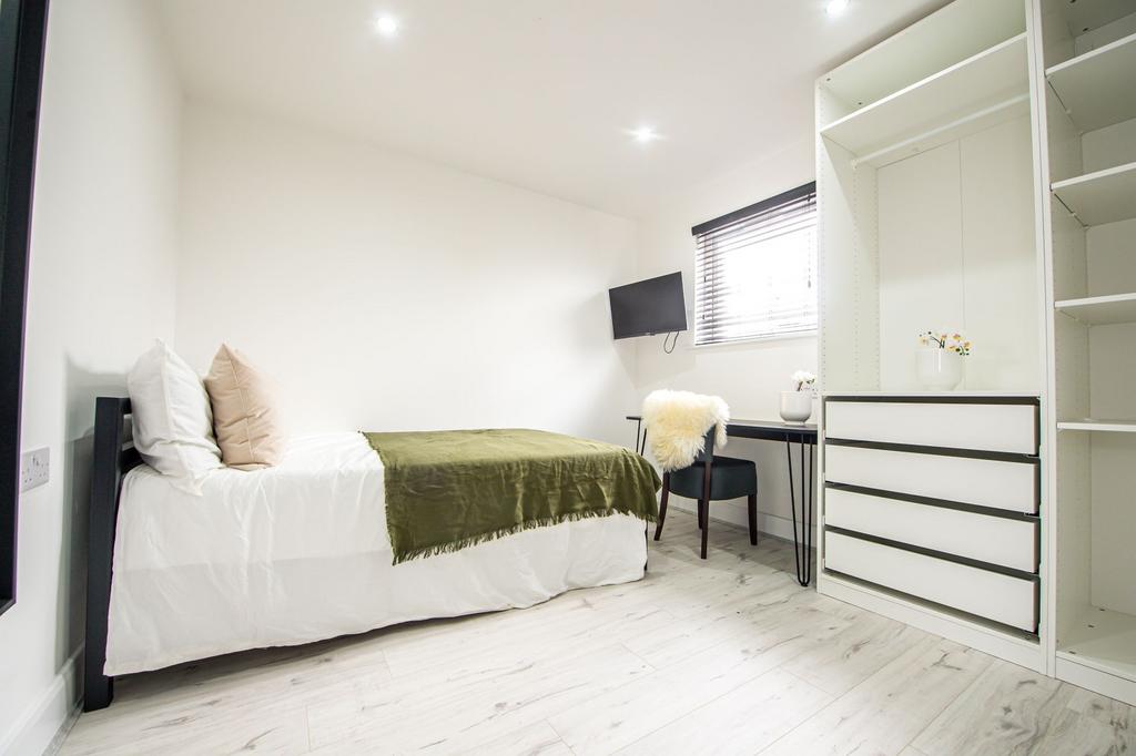A bright and welcoming bedroom featuring a comf...