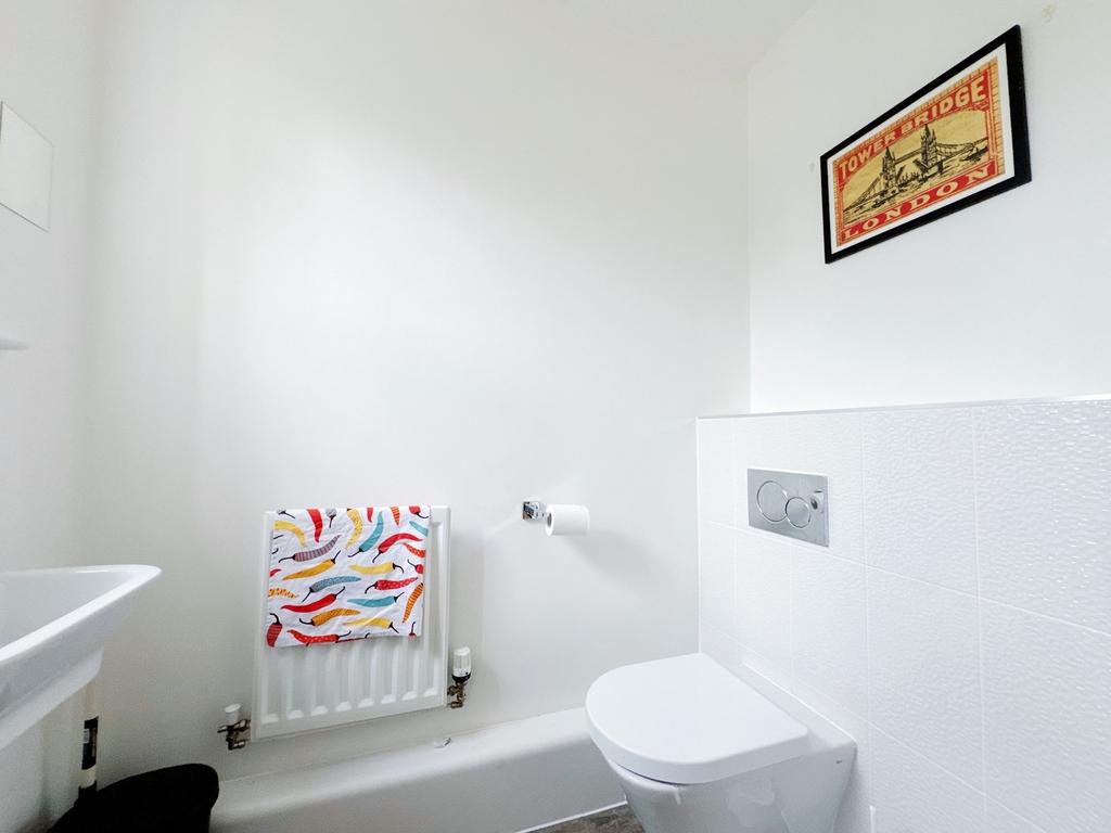 Bright, modern bathroom with a wall-hung toilet...