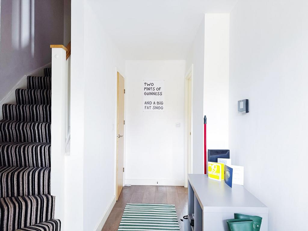 Bright, modern hallway with striped-carpet stai...