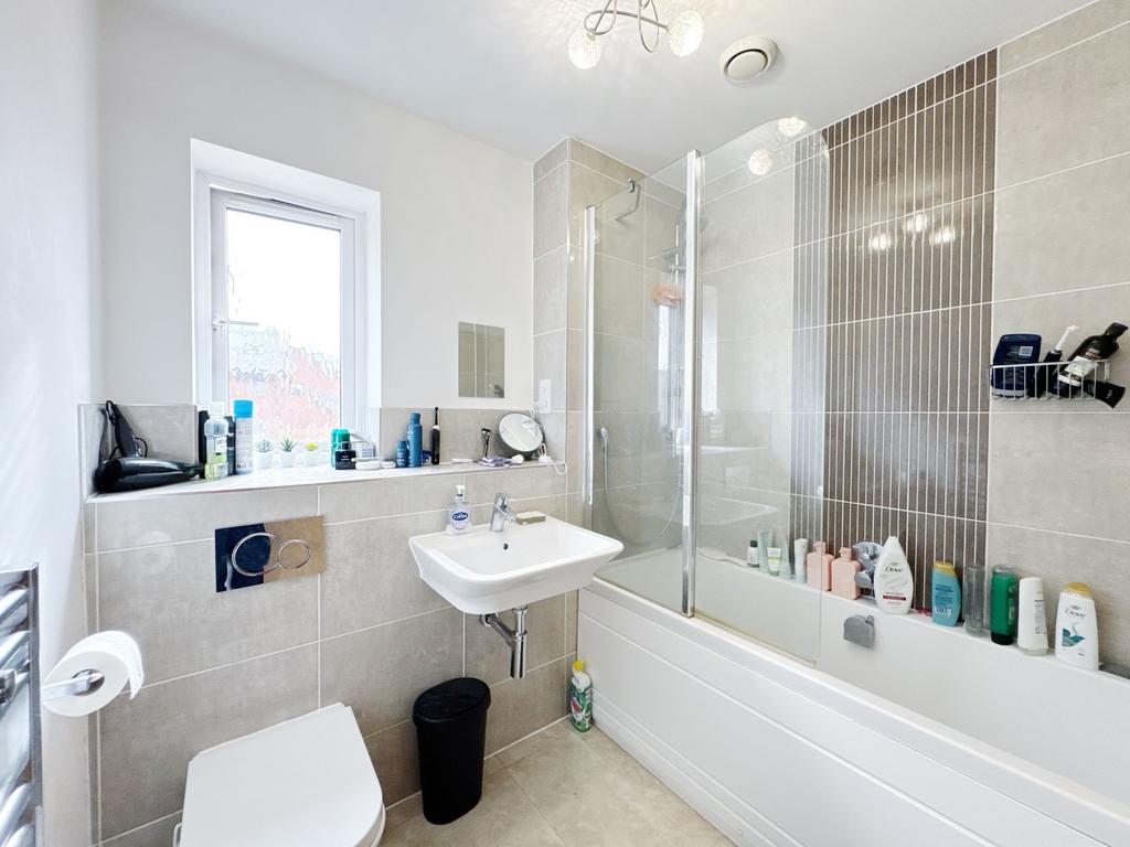 Bright, modern bathroom with a bathtub and glas...
