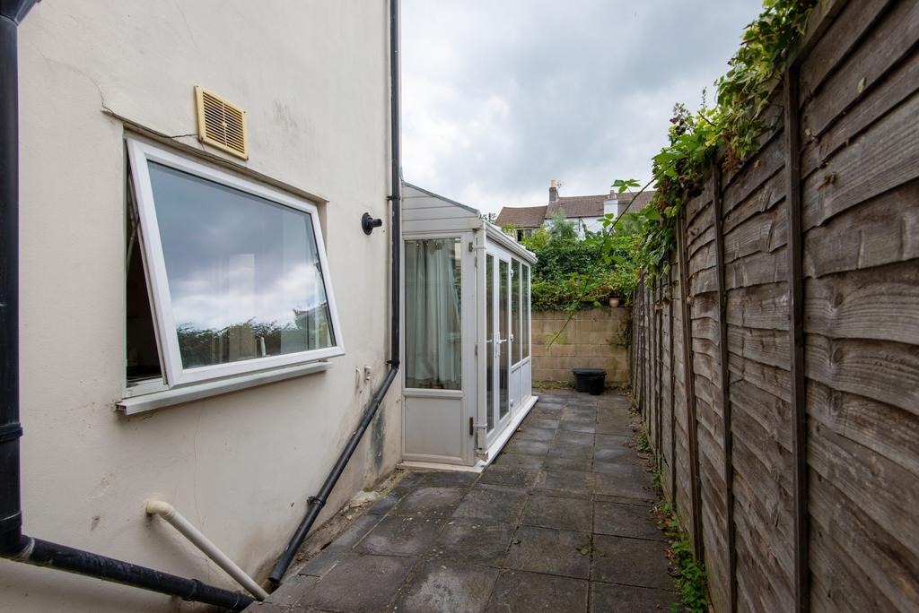 Private paved side alley with a small conservat...