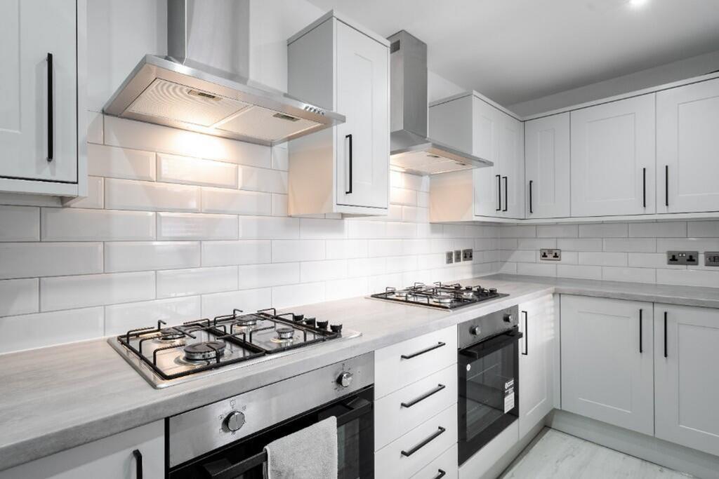 A modern kitchen featuring sleek cabinetry, sta...