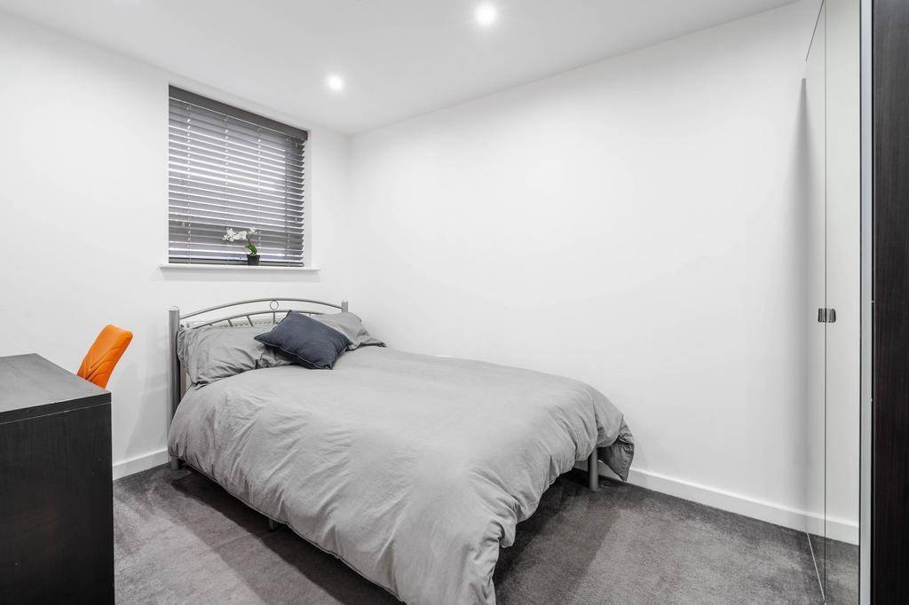 A bright, modern bedroom with a comfortable dou...