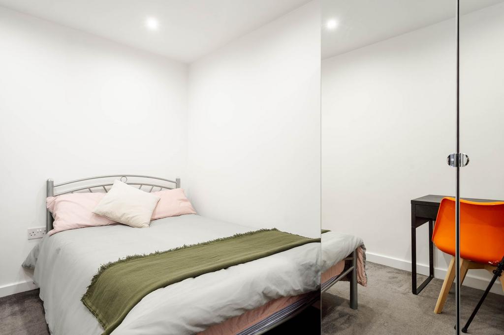 A well-maintained bedroom featuring a cozy doub...