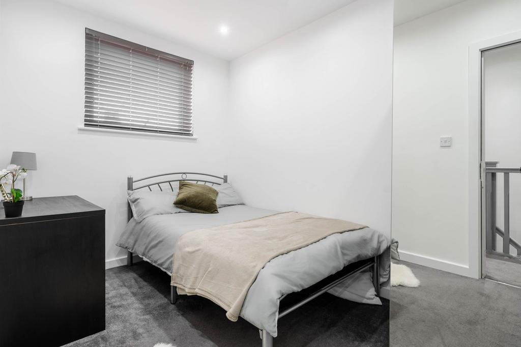 A modern, well-lit bedroom featuring a comforta...