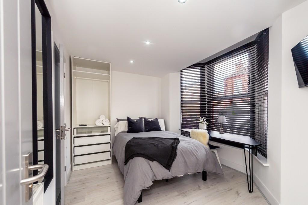 A modern and spacious master bedroom featuring ...