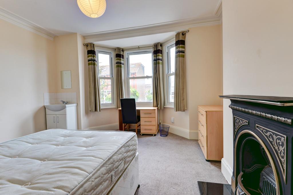 A bright, well-maintained bedroom with large wi...