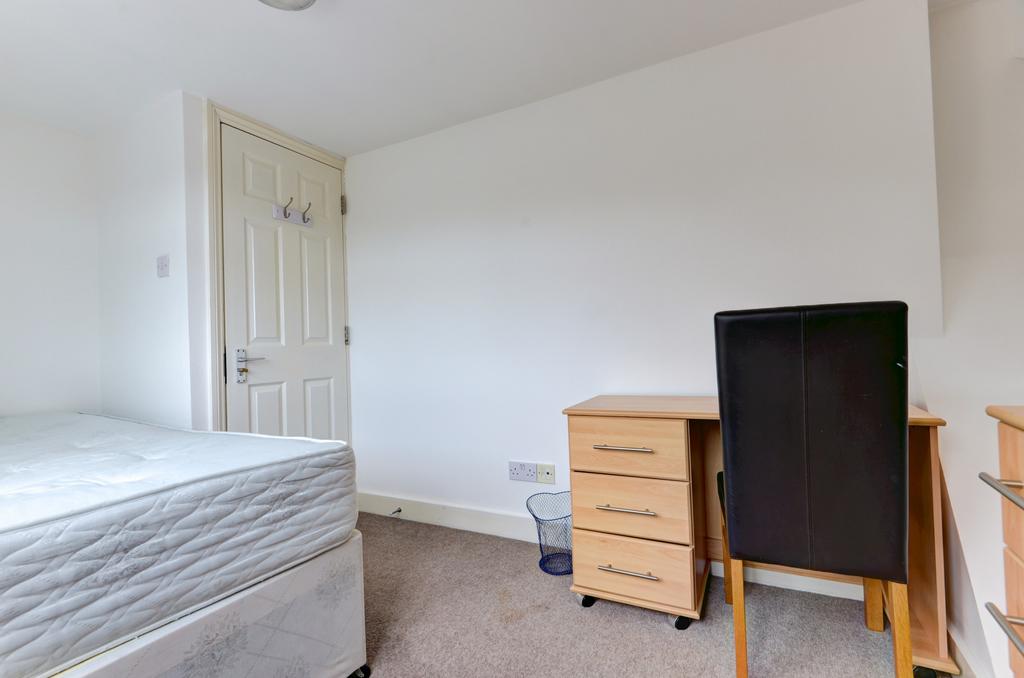 Bright, simply furnished bedroom with a comfort...