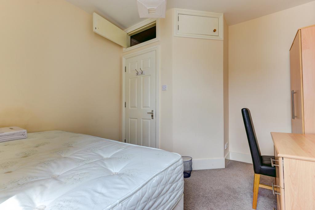 A small room featuring a bed and minimal furnis...