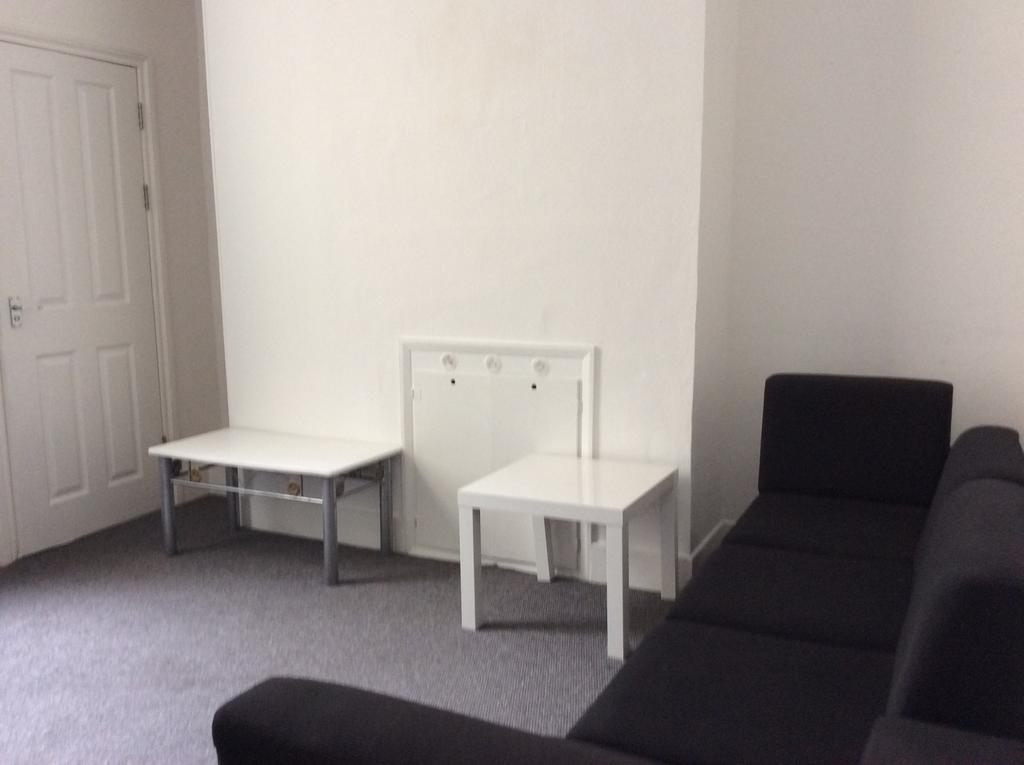 Simple, tidy living room with a dark L-shaped s...