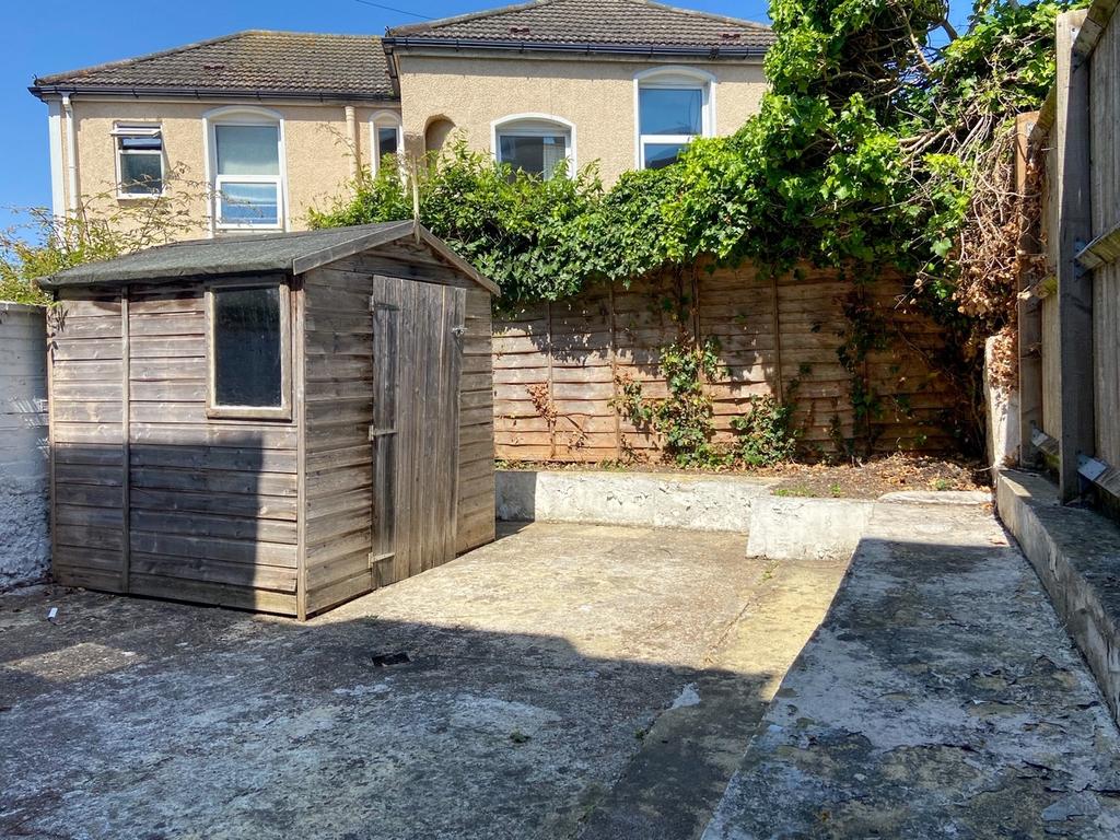 Sunny low-maintenance walled yard with concrete...
