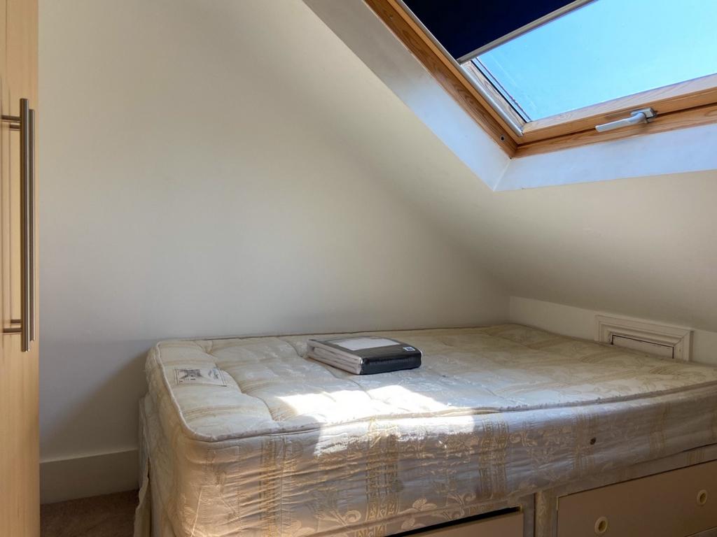Bright loft bedroom with a skylight and built-i...
