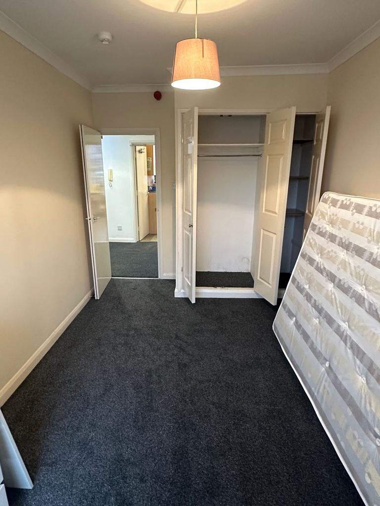 Bright, neutrally decorated bedroom with fitted...
