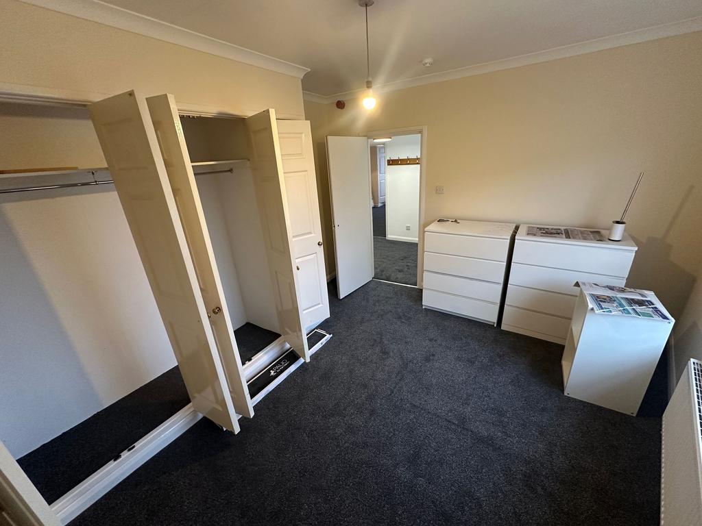 Bright, freshly carpeted bedroom with built-in ...