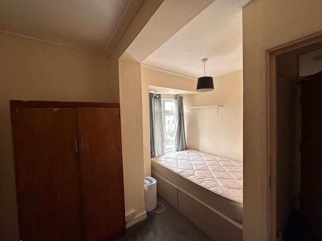 Compact single bedroom with a double-height win...
