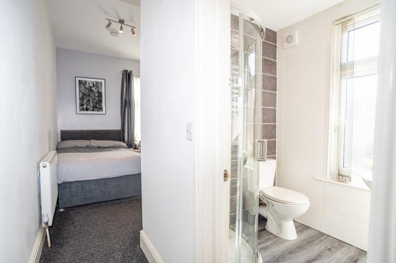 Bright ensuite master bedroom featuring a comfo...