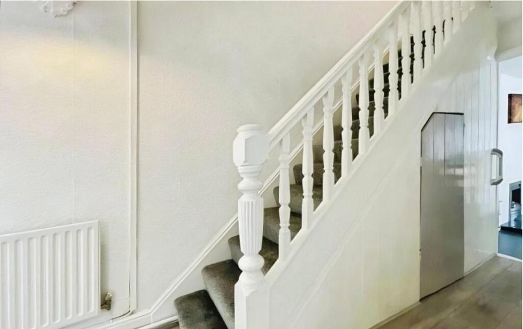 Bright, well-maintained hallway featuring a pai...