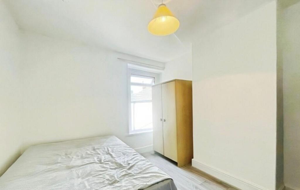 Bright, simply furnished bedroom with a window ...