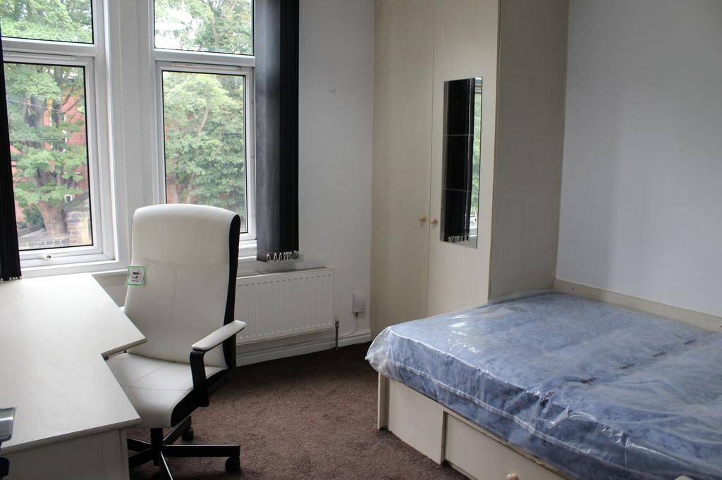 A cozy single bedroom featuring a comfortable b...